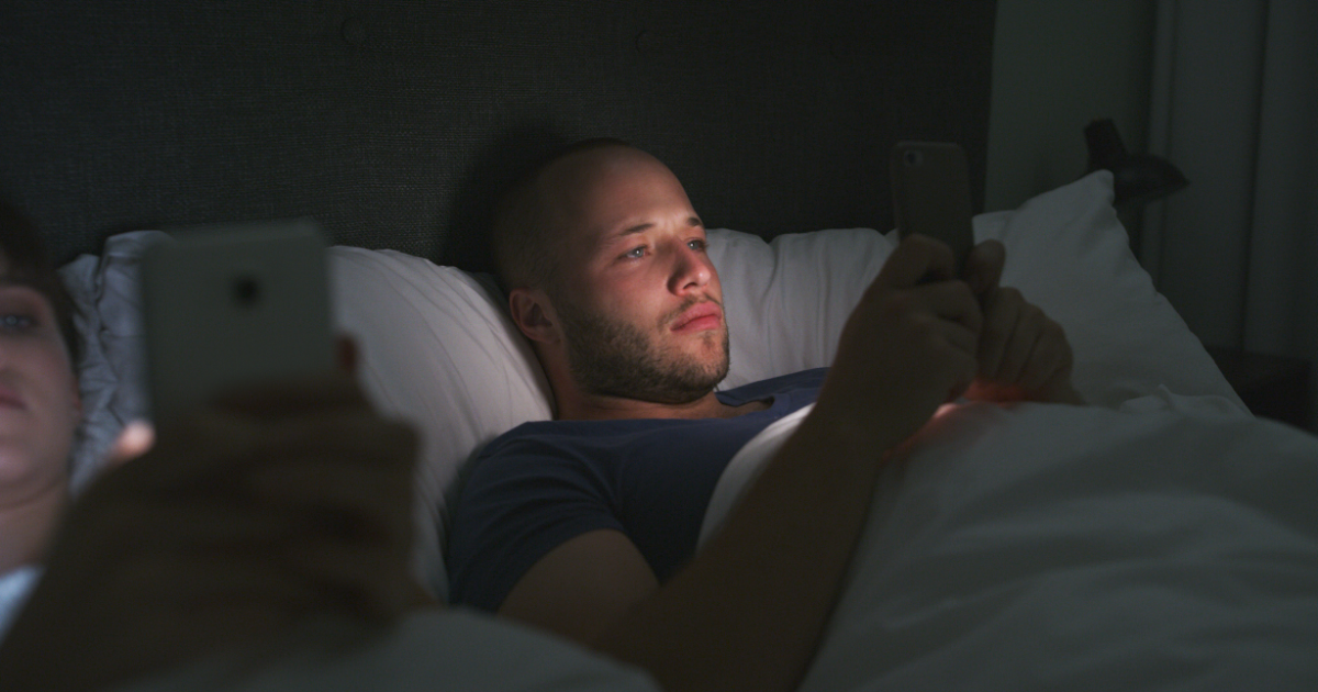 person distracted by smartphone representing short attention span; young adult trying to focus while surrounded by digital notifications 